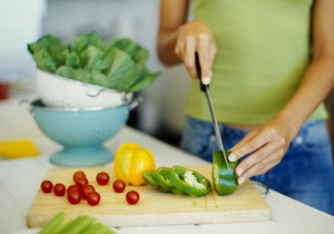 mid section view of a woman cutting vegetables